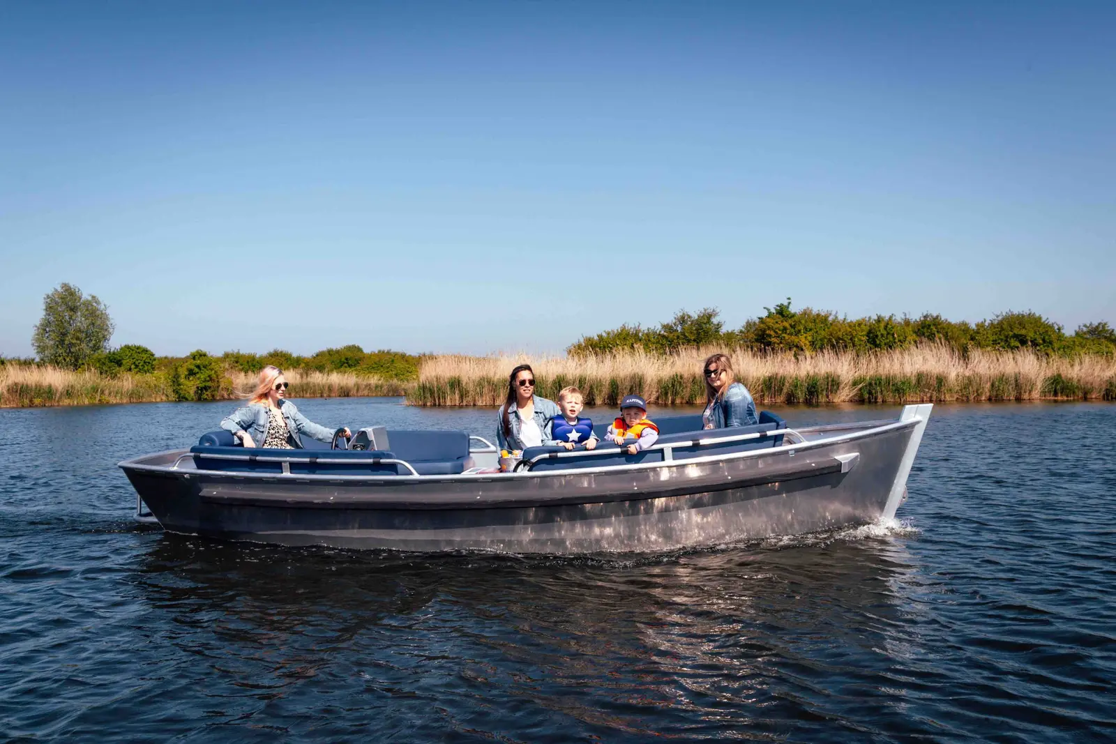Gezin geniet van een dagje varen met een elektrische sloep in Almere