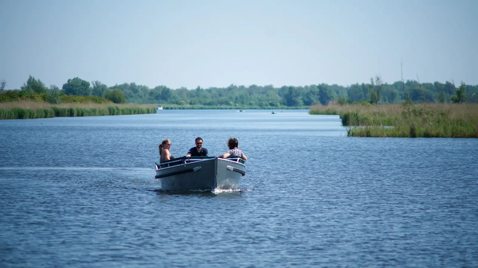 Sloep met gezelschap vaart over het water in Almere