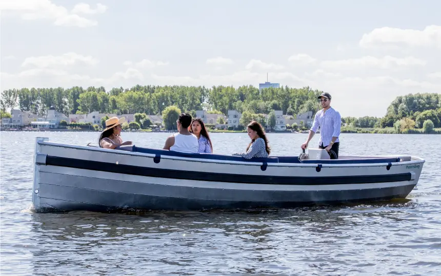 Gezelschap vaart met een sloep vanaf De Kapitein op de Noorderplassen